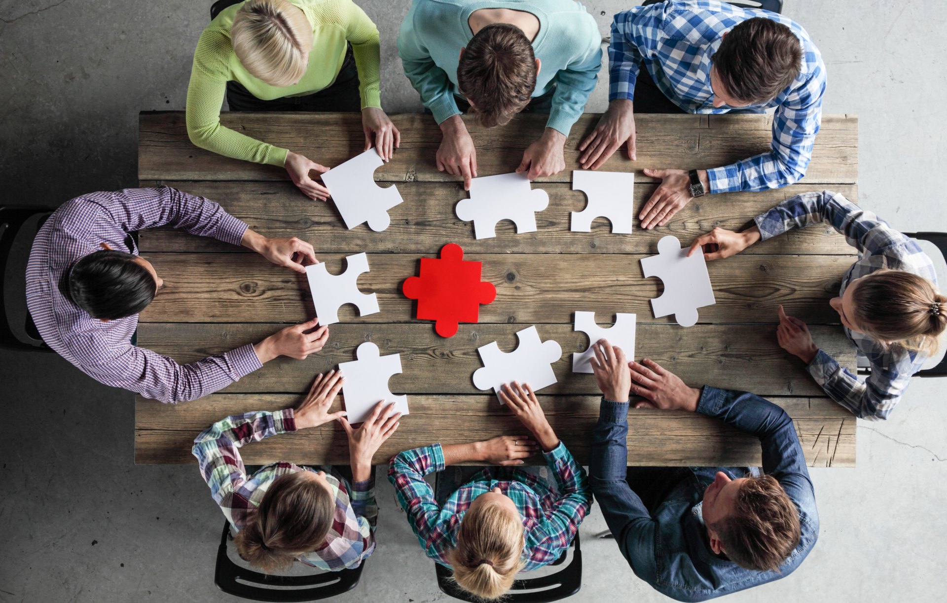 People sitting around a table with puzzle pieces